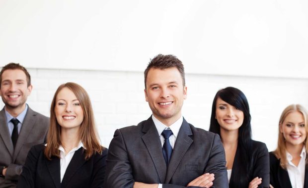 group of certified public accountants that work at a CPA firm smiling