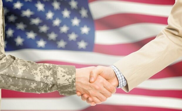 dcaa compliance- american soldier and civil man in suit shaking hands with us flag on background