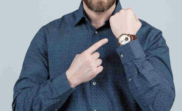 a man pointing at his watch representing DCAA compliant timekeeping