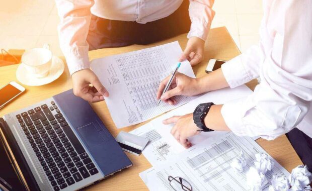 business people hands writing accounts payable document while discussing