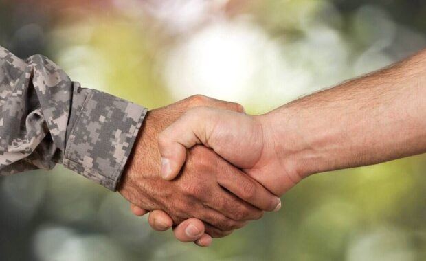 man shaking hand with military person