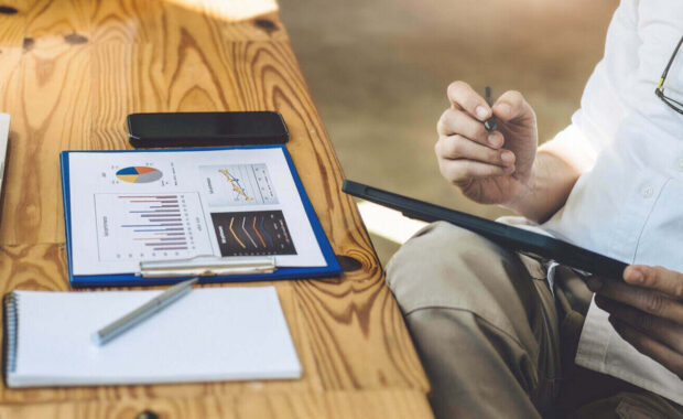 stock analyst holding a pen pointing at a tablet Analyze the stock market to make a profit for your own portfolio