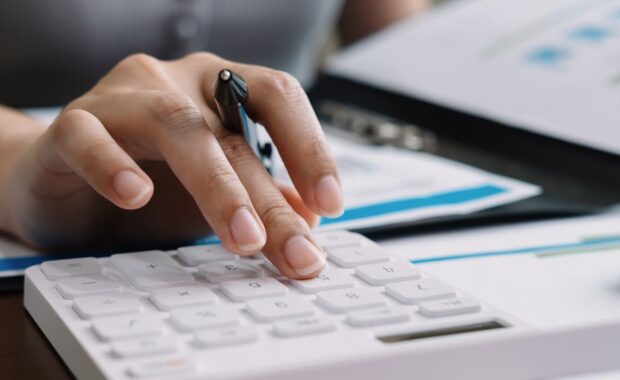 bookkeeper making calculations with calculator