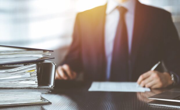 papers are waiting to be processed by unknown man accountant