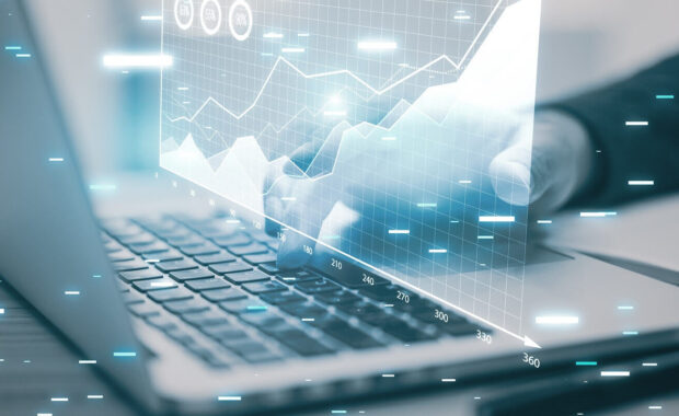 close up of male hands using laptop keyboard at desk with digital business chart hologram on blurry background