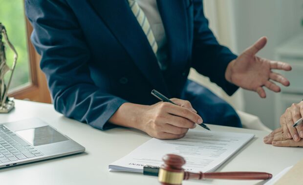 Two government officials reviewing and signing a contract in their office