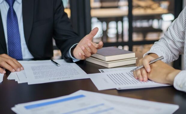 lawyer legal counsel presents to the client a signed contract with gavel and legal law