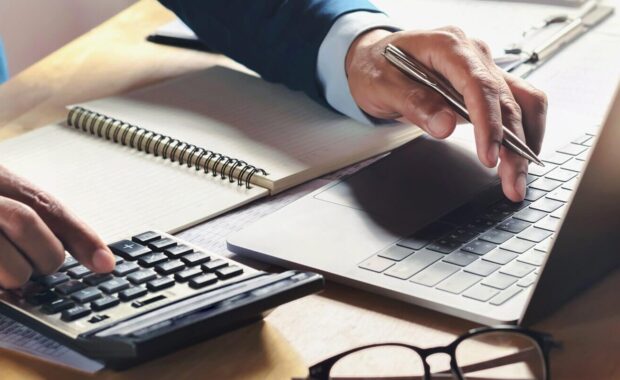 businessman working on desk with using calculator and computer in office