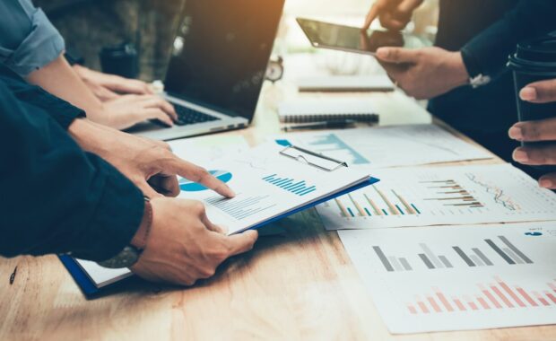 teamwork with business people analysis cost graph on desk at meeting room