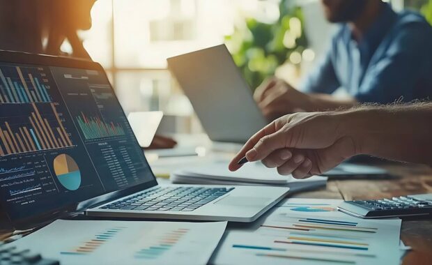 business team analyzing financial data on laptop