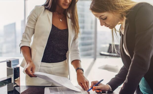 women signing a contract standing in modern appartment