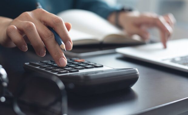 business woman working at office, using calculator to calculate company finance