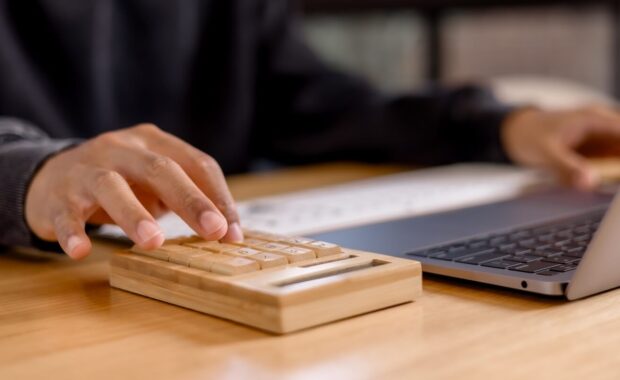 businessman calculating tax with laptop, calculator, and financial documents tax payment planning